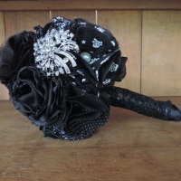 Buquê artesanal na cor preta, com flores de tecido e aplicação de broches.