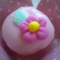 Doce de leite em pó com flor e banhado no chocolate branco colorido