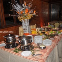Mesa de frios com frutas e massas.