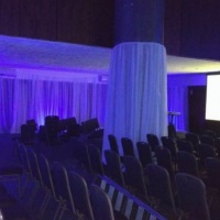 Cortinados de voil branco com iluminação cênica