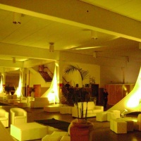 Mobiliários, puffs, plantas ornamentais, iluminação cênica.